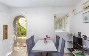 ein Esszimmer mit einem weißen Tisch und blauen Stühlen in der Unterkunft Awesome Apartment In Omisalj With Wifi in Omišalj