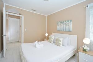 - une chambre blanche avec un grand lit blanc et des oreillers dans l'établissement South of Fifth Ocean Drive Apt, à Miami Beach