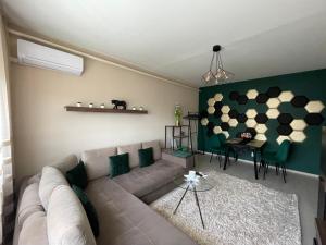 - un salon avec un canapé et une table dans l'établissement Bella Apartman Debrecen, à Debrecen