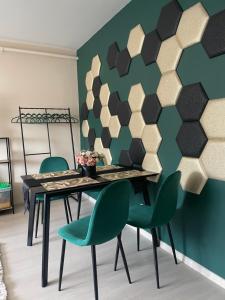 德布勒森的住宿－Bella Apartman Debrecen，一间带桌子和绿色椅子的用餐室