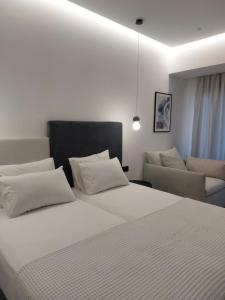 バリにあるAnastasia Apartmentsの大きな白いベッドとソファのある寝室