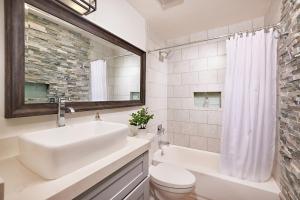 a bathroom with a sink and a toilet and a mirror at Fantastic Ocean View Remodeled All New Furnishings Pet Friendly AC in Oceanside +27 photos