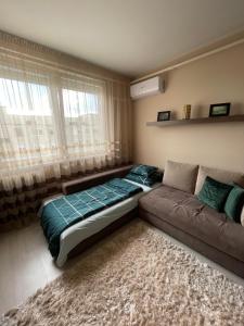 ein Schlafzimmer mit einem Bett und einer Couch und einem Fenster in der Unterkunft Bella Apartman Debrecen in Debrecen + 20 Fotos