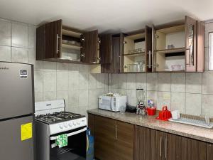 y cocina con fogones y nevera. en Confort Home - Apartamento ¨Dalias¨, en Baños