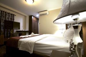 a hotel room with a bed and a lamp at Katesiree House in Pattaya