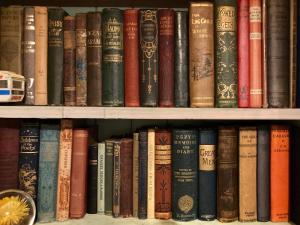 a bunch of books sitting on a shelf at The Writers Cottage - Intriguing & Romantic in Holmfirth