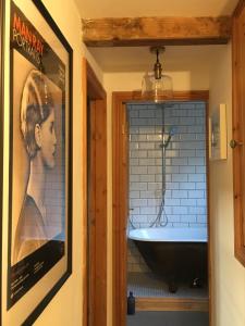 El baño incluye un cartel de películas y una bañera. en The Writers Cottage - Intriguing & Romantic, en Holmfirth