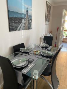 una mesa de comedor con copas de vino y una foto de un faro en ChezVous, en Swords