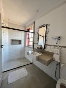 uma casa de banho com um lavatório e um espelho em Pousada Tiradentes em Tiradentes
