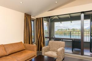 sala de estar con sofá y silla en Copthorne Hotel & Resort Lakefront Queenstown, en Queenstown