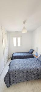 聖瑪麗亞港的住宿－Casa Playa de Valdelagrana，一间卧室配有两张带蓝色棉被的床