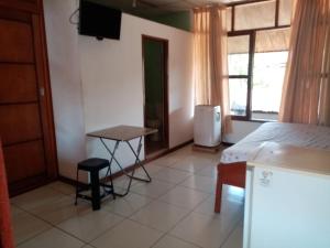 a bedroom with a bed and a table and a window at Hospedaje Casa Amazónica Iquitos in Iquitos