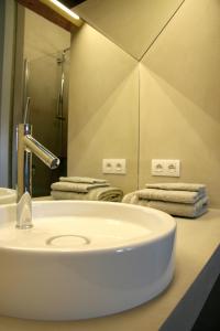 een badkamer met een witte wastafel en een spiegel bij B&B Hof ter Kwaremont in Kluisbergen