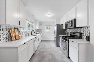 una cocina blanca con armarios y electrodomésticos blancos en Gorgeous Downtown Bungalow en Coeur d'Alene