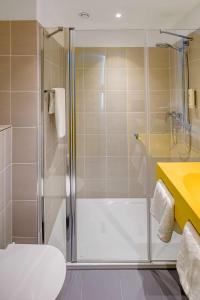 a bathroom with a shower and a toilet and a sink at prizeotel Münster-City in Münster