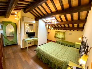 a bedroom with a green bed and a desk at Agriturismo Il Casale in Morrovalle