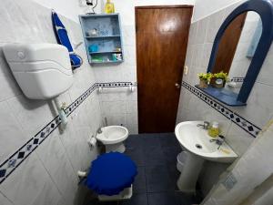 a small bathroom with a toilet and a sink at GUSMAR - Hermosa y confortable casa a pasos de la playa. in Santa Ana