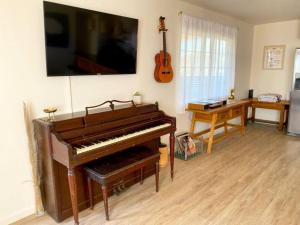 a living room with a piano and a guitar at Cryptic Cabin-Tranquil Bohemian Getaway w/Hot Tub in Yucca Valley