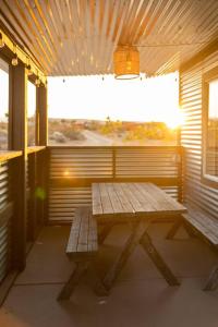 mesa de picnic y banco en una habitación con ventana en Cryptic Cabin-Tranquil Bohemian Getaway w/Hot Tub, en Yucca Valley