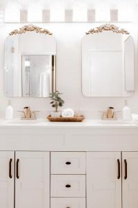 ein weißes Badezimmer mit zwei Waschbecken und zwei Spiegeln in der Unterkunft PRESIDENTIAL SUITE MOUNTAIN/LAKE VIEWS w/HEATED POOLS- PGA WEST in La Quinta