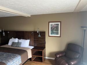 une chambre d'hôtel avec un lit et une chaise dans l'établissement Towne inn, à Sylacauga