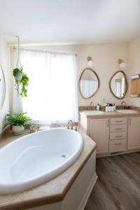 a large bathroom with a large tub and two sinks at Hemingway House - Hot Tub Under The Desert Stars in Yucca Valley