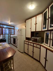a kitchen with a refrigerator and a table in it at Apartamento Alto da Serra - 024 in Gramado