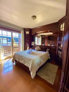 a bedroom with a bed and a large window at Apartamento Alto da Serra - 024 in Gramado