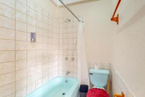 un bagno con una vasca blu e un water di Island Cabanas Gold Standard Certified a Caye Caulker