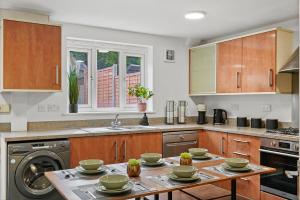 a kitchen with a table with dishes on it at Townhouse in Dartford sleeps 8 with free parking in Dartford