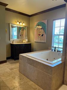 a large bathroom with a large tub and a sink at Private Oceanfront Escape: Kayaks, Sunsets, Coral! 