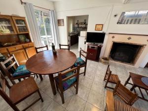 sala de estar con mesa, sillas y chimenea en GUSMAR - Hermosa y confortable casa a pasos de la playa., en Santa Ana