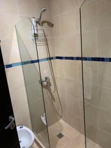 a shower with a glass door next to a toilet at EDU'S HOUSE i in Guaymallen