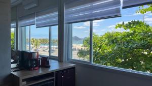 cocina con ventanas y vistas a la playa en Estúdio Moderno com Vista Oceânica, en Río de Janeiro