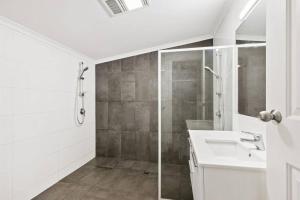 a white bathroom with a sink and a shower at 4-Bedroome home, new bathrooms and close to town in Kalgoorlie