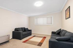 a living room with two couches and a television at 4-Bedroome home, new bathrooms and close to town in Kalgoorlie