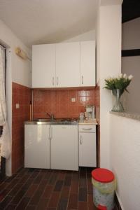 een keuken met witte kasten en een vaas met bloemen bij Apartments with a parking space Stinjan, Pula - 7201 in Pula