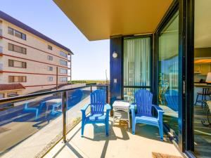 a balcony with blue chairs and a view of a building at Sand & Sea: Beach Dreams (112) in Seaside
