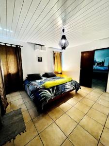 波拉波拉的住宿－KAHAI LODGE Maison tout confort et spacieuse à Bora Bora，一间卧室配有一张带冲浪板的床