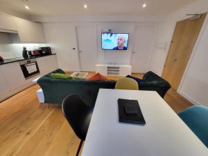 a living room with a couch and a tv at City Centre Stylish Apartment Croydon-Free Parking Provided in Croydon