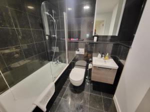 a bathroom with a toilet and a tub and a sink at City Centre Stylish Apartment Croydon-Free Parking Provided in Croydon