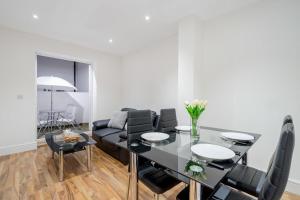 a living room with a black table and chairs at City Sparrow Apartment Pad -1 in London