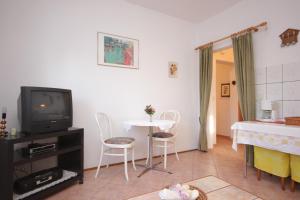 a living room with a tv and a table and chairs at Apartments by the sea Okrug Gornji, Ciovo - 8441 in Trogir