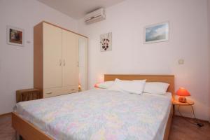 a bedroom with a large bed and a white cabinet at Apartments by the sea Okrug Gornji, Ciovo - 8441 in Trogir