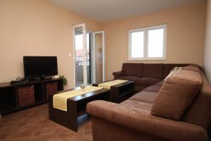 een woonkamer met een bank en een flatscreen-tv bij Apartments by the sea Stari Grad, Hvar - 8704 in Stari Grad