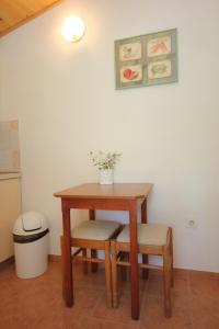 米利尼的住宿－Apartments and rooms by the sea Srebreno, Dubrovnik - 8957，一张木桌和椅子,上面有花瓶