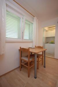 a table and chair in a room with a kitchen at Apartments and rooms by the sea Srebreno, Dubrovnik - 8957 in Mlini +37 photos