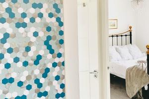 a bedroom with a blue and white patterned wall at Entire home: Bicester Village 10min walk (650m) in Bicester
