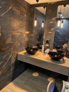 uma casa de banho com dois lavatórios e dois espelhos em OLÉ Hotel em Hamburgo