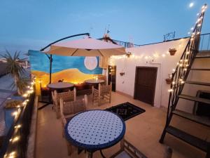 een patio met tafels en stoelen en een parasol bij Terrace House 88 in Marrakesh